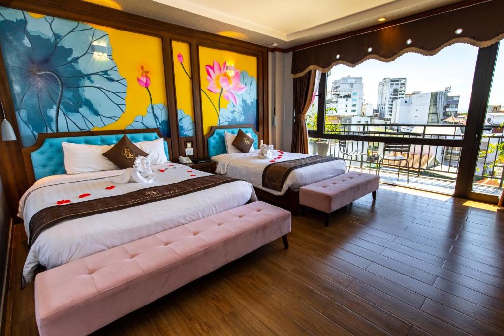 a bedroom with two beds and a view of a city at Jade Scene Hotel in Hue