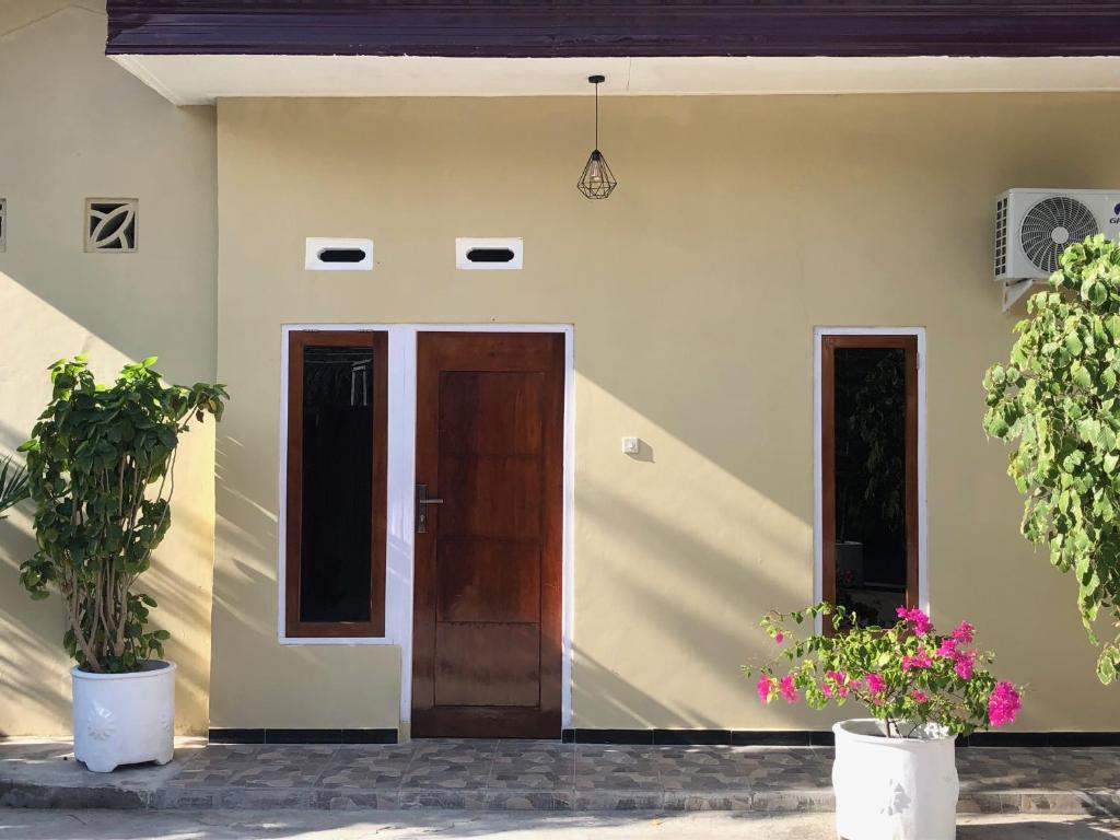 a house with two doors and two potted plants at LOPE HOMESTAY in Ndangu