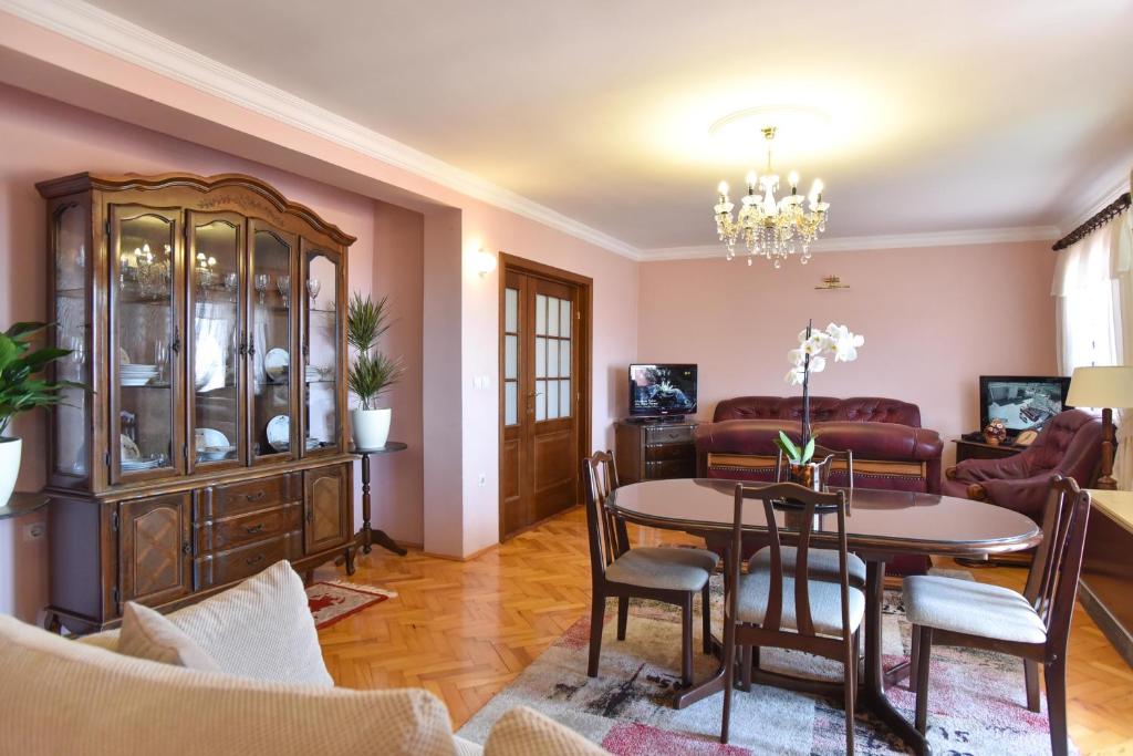 ein Wohnzimmer mit einem Tisch und einem Esszimmer in der Unterkunft Vila Apartments Lidija in Petrovac na Moru