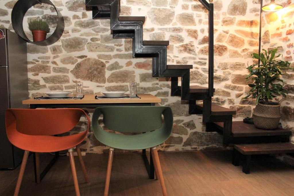 einen Tisch mit 2 Stühlen und eine Treppe in einem Zimmer in der Unterkunft Theane lime 1 in Kavala