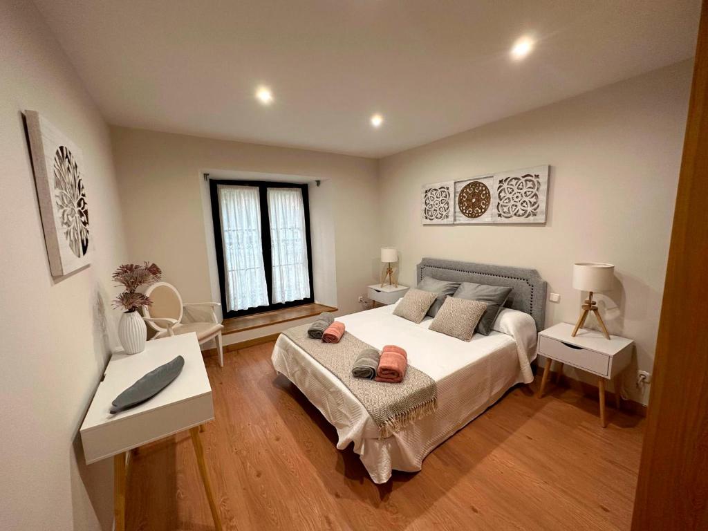 ein Schlafzimmer mit einem großen Bett und zwei Tischen in der Unterkunft Apartamento Lujo centro histórico in Valladolid