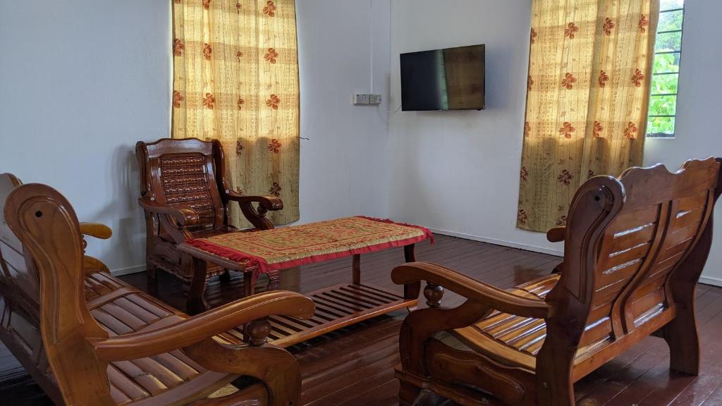 una camera con due sedie, un tavolo e una TV di Ayana Homestay a Labuan