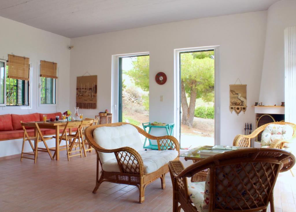a living room with chairs and a table at Caper & Olive mountain cottage in Vathí