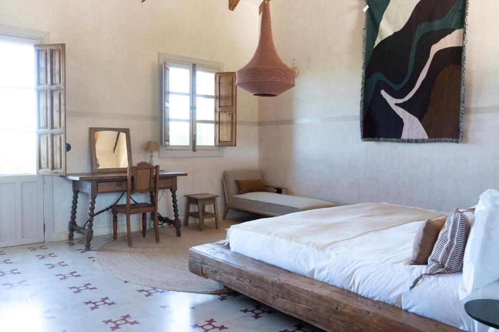 a bedroom with a bed and a desk and a piano at Casa La Siesta in Vejer de la Frontera