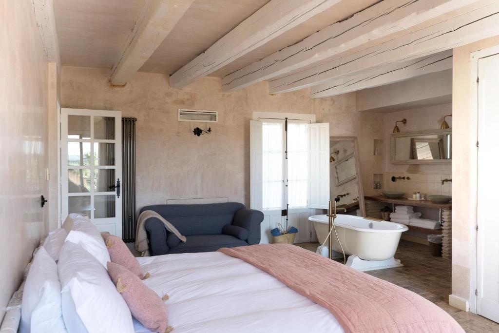 a bedroom with a large bed and a bath tub at Casa La Siesta in Vejer de la Frontera