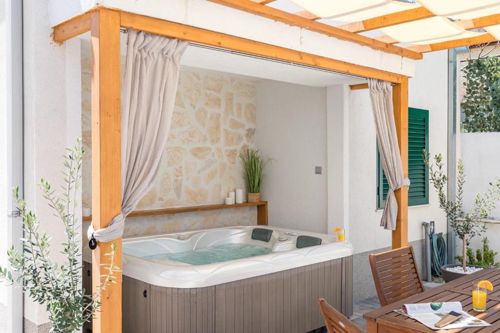 un patio con mesa y bañera de hidromasaje. en Tonina apartment - house with patio, jacuzzi, free parking, en Split