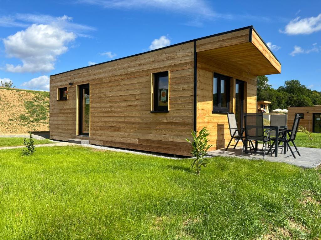 a small wooden house with a green lawn at Ferienresort Edersee GmbH in Hemfurth-Edersee