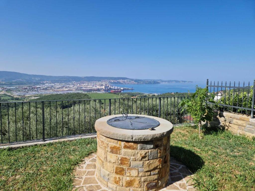 a fire pit on a hill with a view of the water at Villa ELM in Ankaran