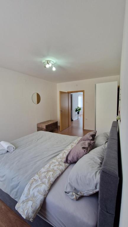 um quarto com uma cama grande com almofadas em Apartmani SKY 1 2 3 em Brcko