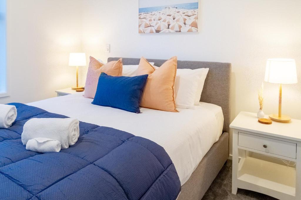 a bedroom with two beds with blue and orange pillows at Modern Comforts 2 bed 2 bath Inner City in Christchurch
