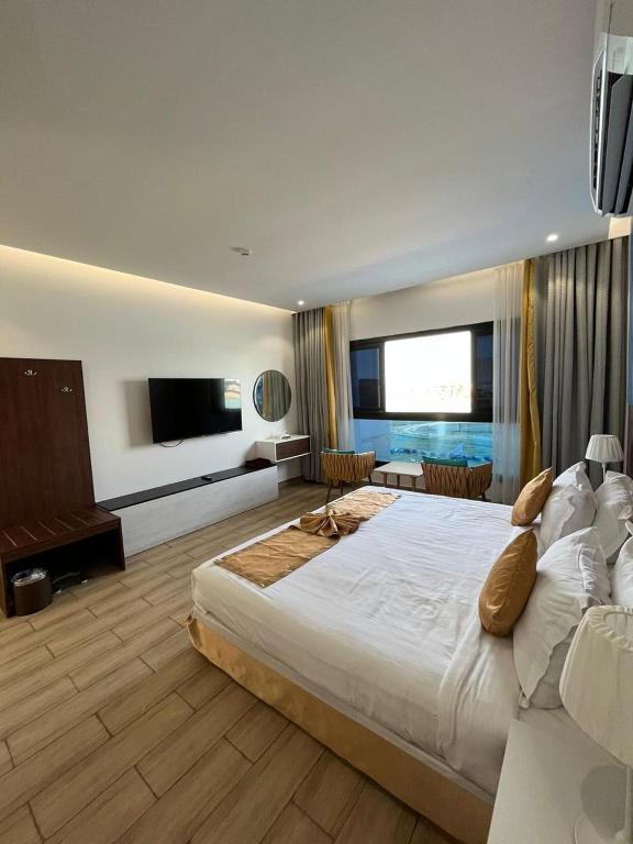 um quarto grande com uma cama grande e uma televisão em درة العروس استوديو على شاطئ البرادايس - عوائل em Durat Alarous