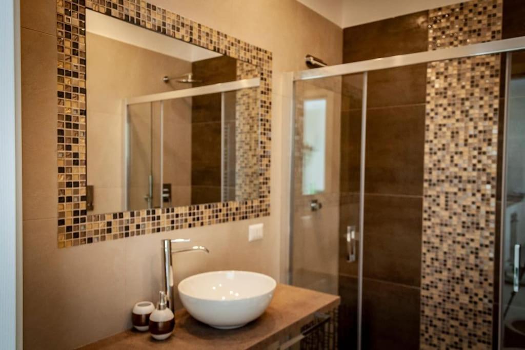 een badkamer met een wastafel en een douche bij Piccolo appartamento di charme in Napels