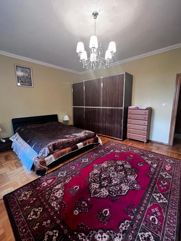 a bedroom with a large bed and a red rug at Spacious rooms in peaceful Jelgava area in Jelgava