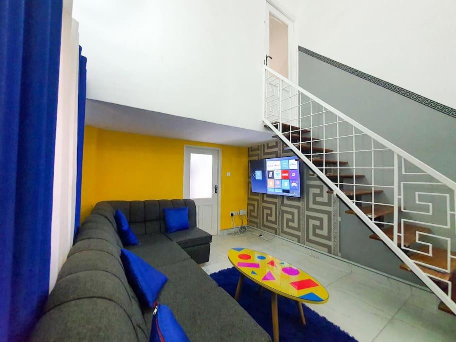 sala de estar con sofá y escalera en 1 bedrm Apt wi-fi rooftop pool en Mombasa