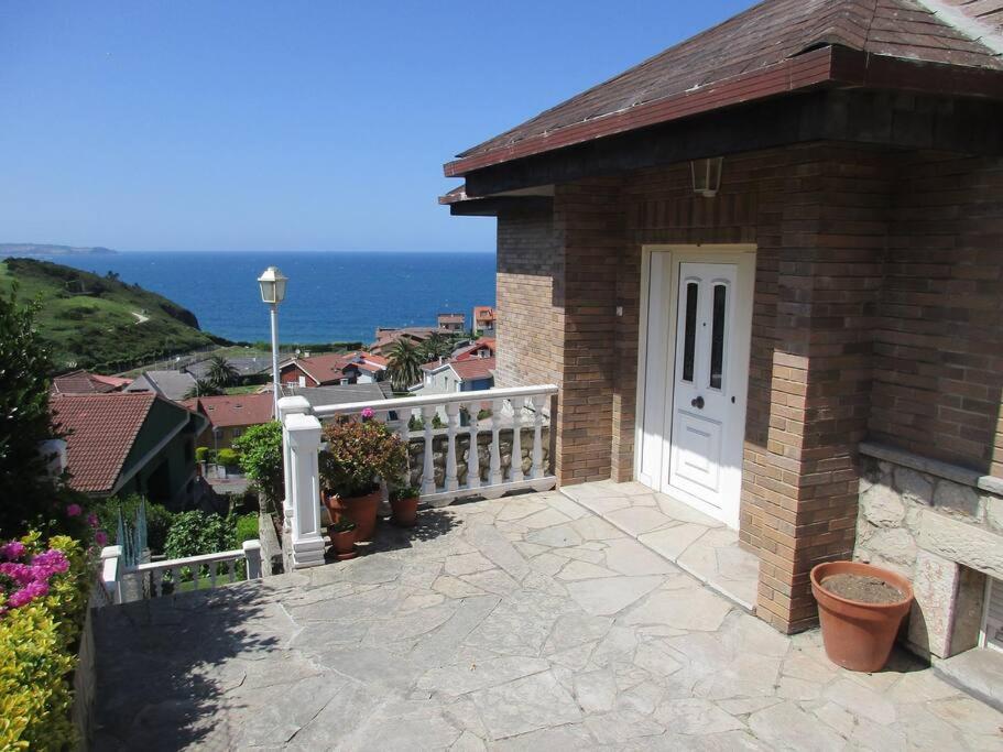 ein Backsteinhaus mit einer weißen Tür und einem Balkon in der Unterkunft MyHouseSpain -Xivares, Chalet con vistas al mar in Carrió