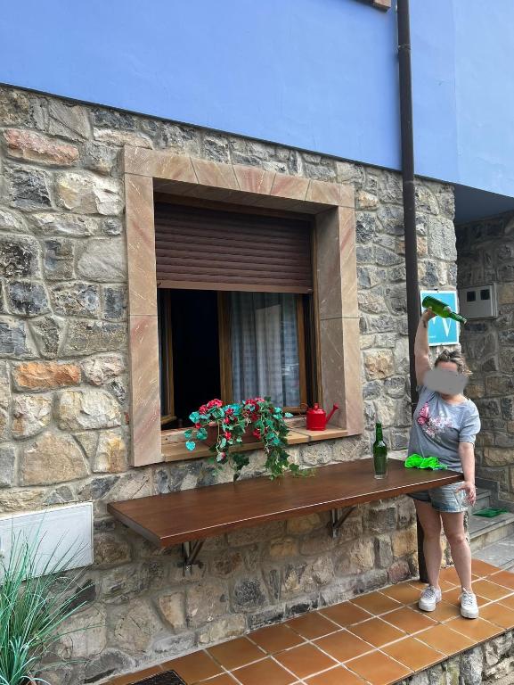 a child standing on a bench looking into a window at Casa la melliza VV-3021AS in Mestas de Con