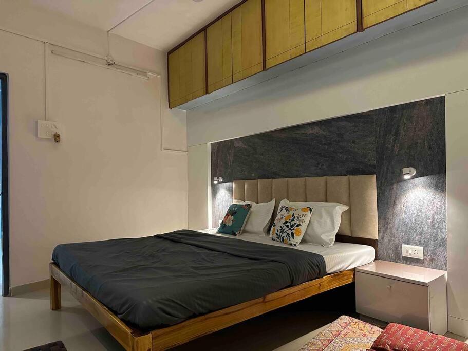 - une chambre avec un grand lit et une grande tête de lit dans l'établissement Lux Flat, à Kolhapur