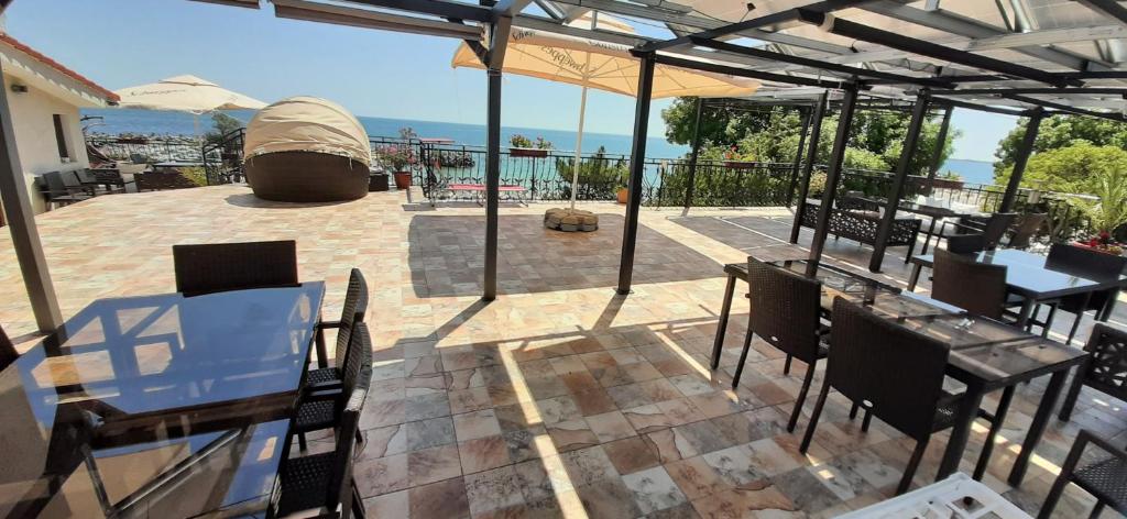 a patio with tables and chairs and an umbrella at Vila pe plaja nr 9 in Saturn