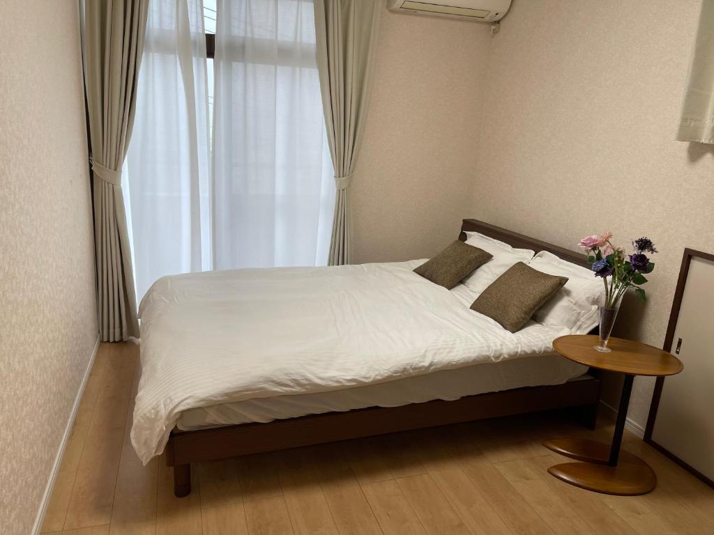 sypialnia z łóżkiem z wazonem kwiatów w obiekcie 日式庭院豪宅 