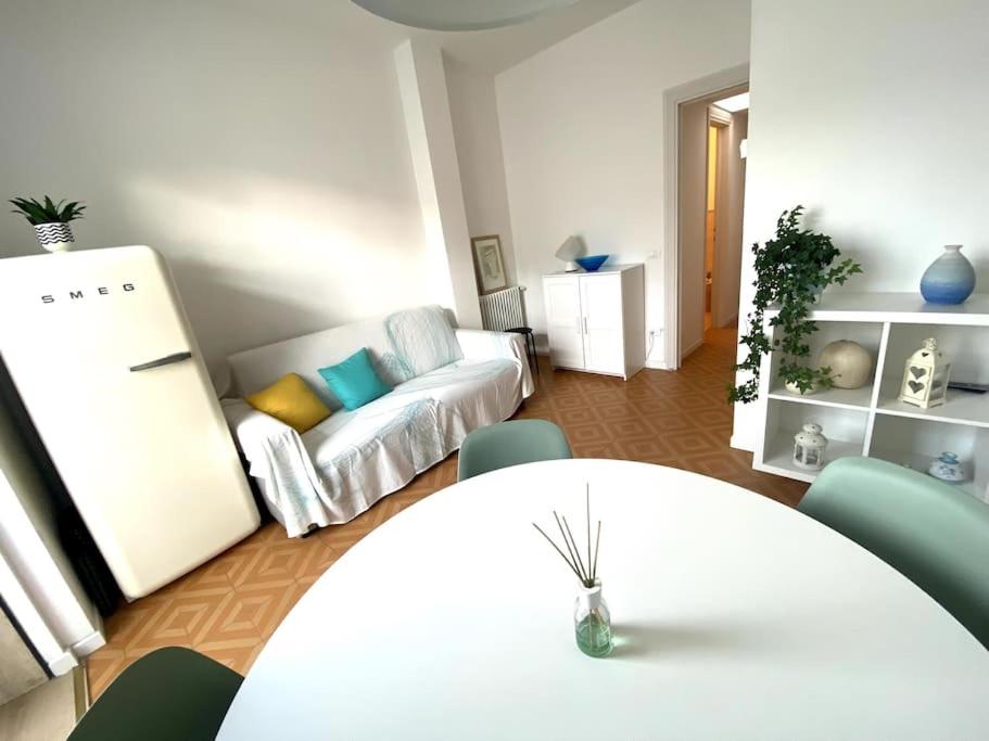 uma sala de estar com uma mesa branca e um sofá em Appartamento in pieno centro - 500 metri dal mare. em Viareggio