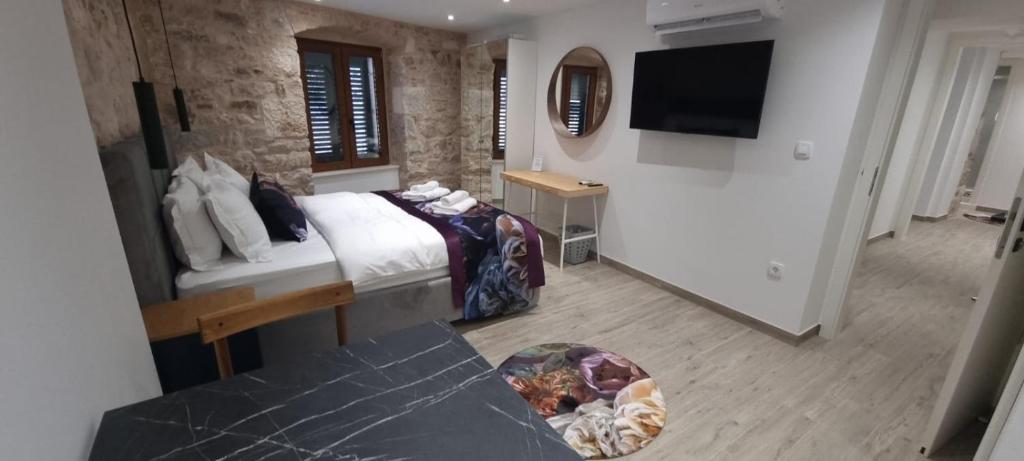 a hotel room with a bed and a flat screen tv at Wila properties doo Studio Christopher in Split