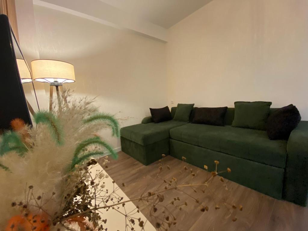 un salon avec un canapé vert et une lampe dans l'établissement Apartment Nizami Kutaisi, à Koutaïssi