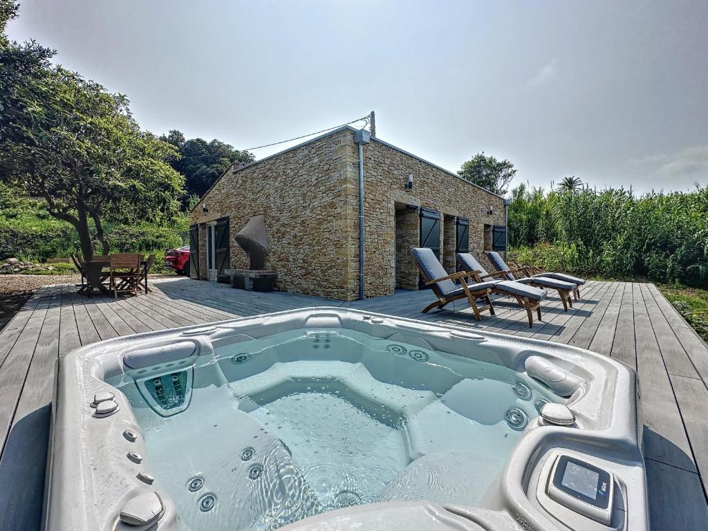 a large hot tub on a deck with a house at Villa 2 chambres avec jacuzzi in Bonifacio