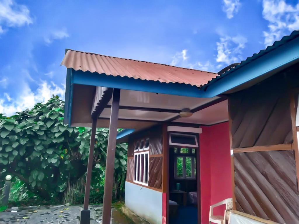 uma pequena casa com uma fachada vermelha e azul em The Himalayan Resort em Ravangla