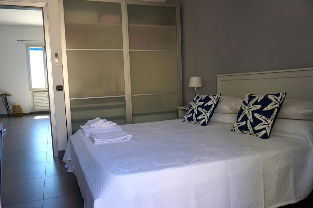 a bedroom with a large white bed with pillows at marefuori in Trapani