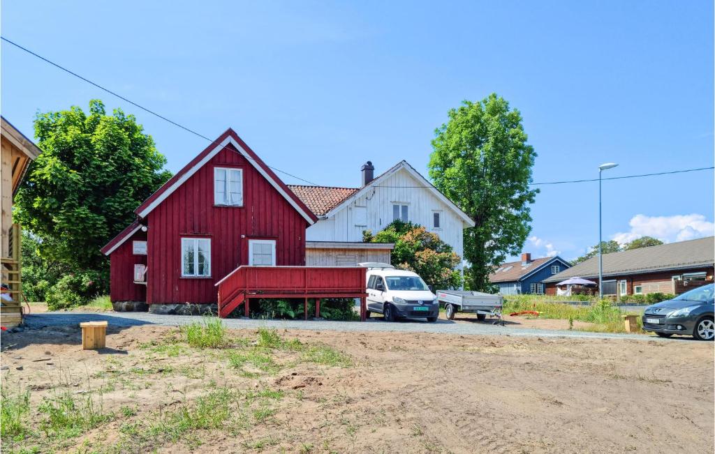 une maison rouge avec une camionnette garée devant elle dans l'établissement Stunning Home In Risr With Kitchen, à Risør