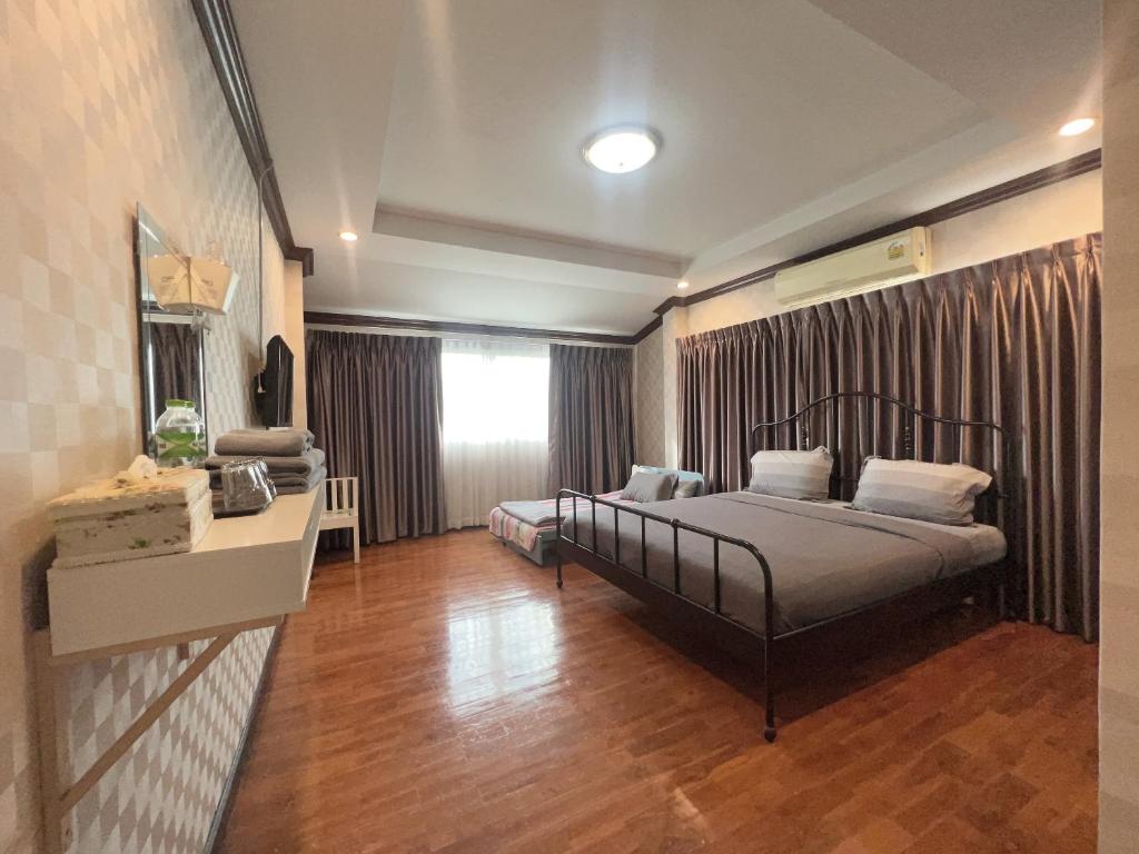 1 dormitorio con cama y ventana en 24 Hostel Donmuang, en Thung Si Kan
