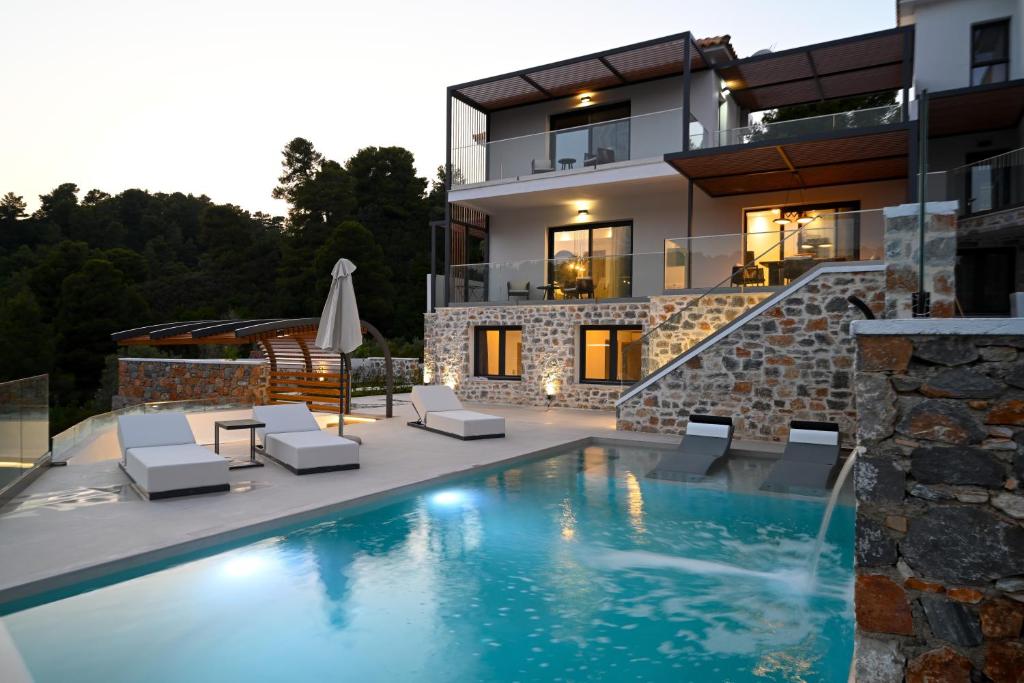 a house with a swimming pool in front of a house at ROYAL VIEW VILLAS in Skiathos