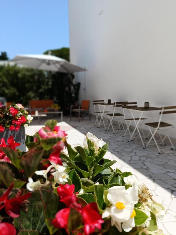 a table with red and white flowers on a patio at KipoRooms in Zollino