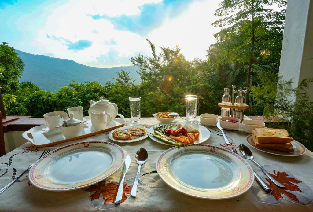 a table with plates of food on it with a view at Hilltop Retreat Matale in Matale