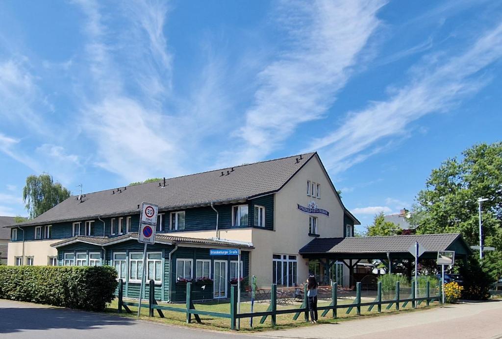 eine Person, die vor einem Gebäude steht in der Unterkunft Spreewaldhotel Seerose in Burg