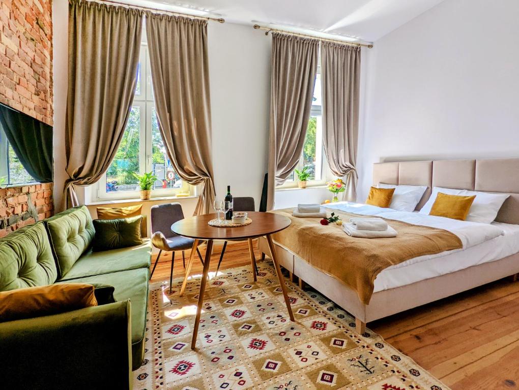 Apartamenty Strzelecka 34 في بوزنان: غرفة نوم بسرير وطاولة واريكة