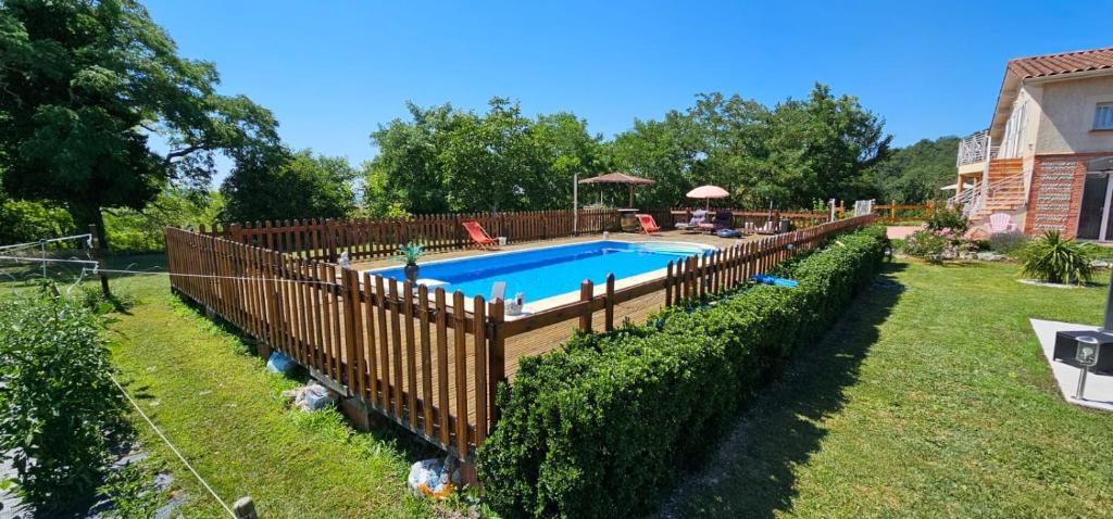 a wooden fence around a swimming pool in a yard at Villa Monplaisir Zen in Latrape