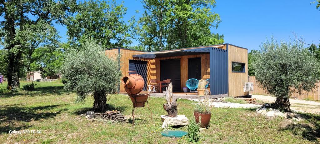 une petite maison dans une cour avec un jardin dans l'établissement Tiny House sud du Lot, à Le Montat