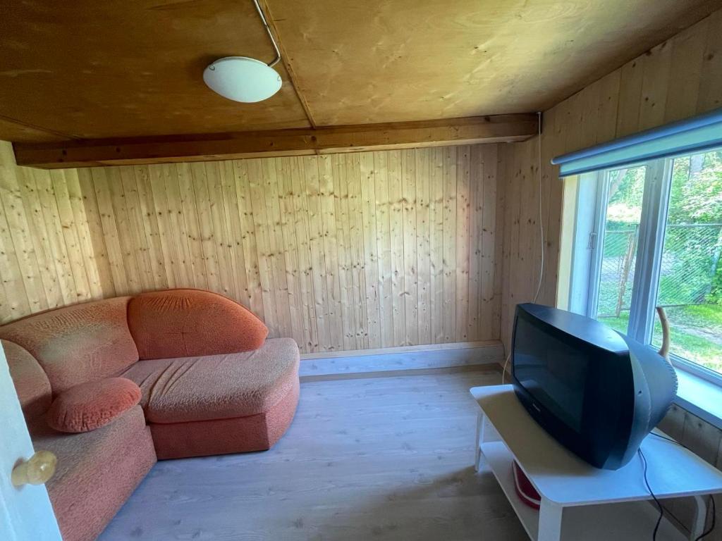 ein Wohnzimmer mit einem Sofa und einem TV in der Unterkunft Kuru village in Kuru