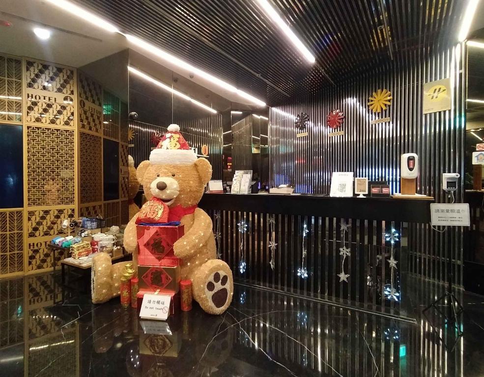 un osito de peluche sentado en una mesa en una tienda en Hotel J Taoyuan, en Pingzhen