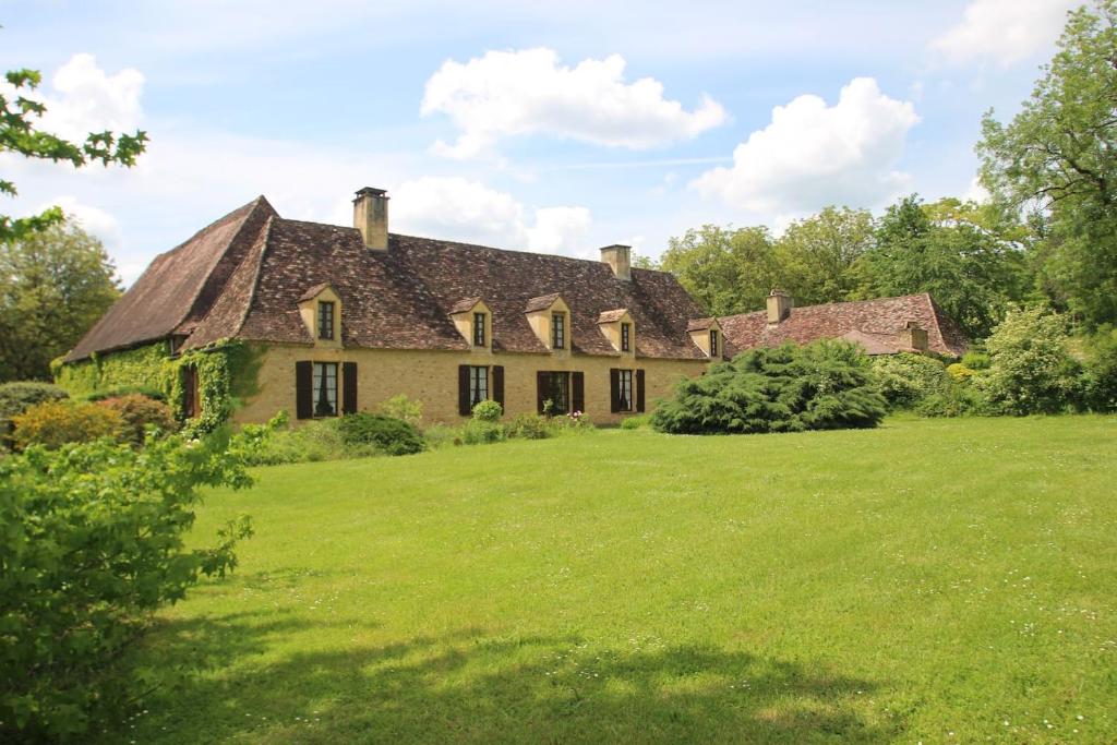 une maison ancienne avec une grande pelouse dans l'établissement La Couture, à Montferrand-du-Périgord