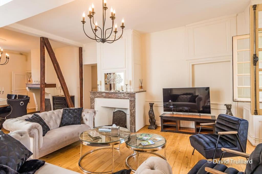 a living room with a couch and a fireplace at Suites Mana - MATAHINA avec VUE SUPERBE sur la Place DUCALE et Parking privé inclus in Charleville-Mézières