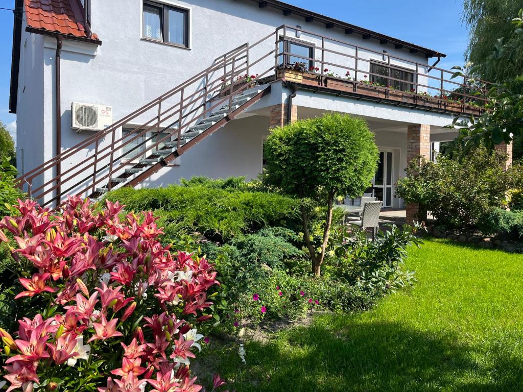 a house with a balcony and some flowers at Słoneczny Wodnik in Braniewo