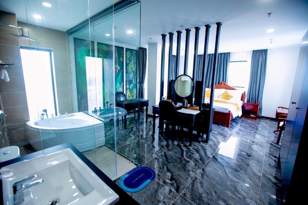 ONE HOTEL في فينه لونج: حمام مع حوض ومغسلة وغرفة نوم