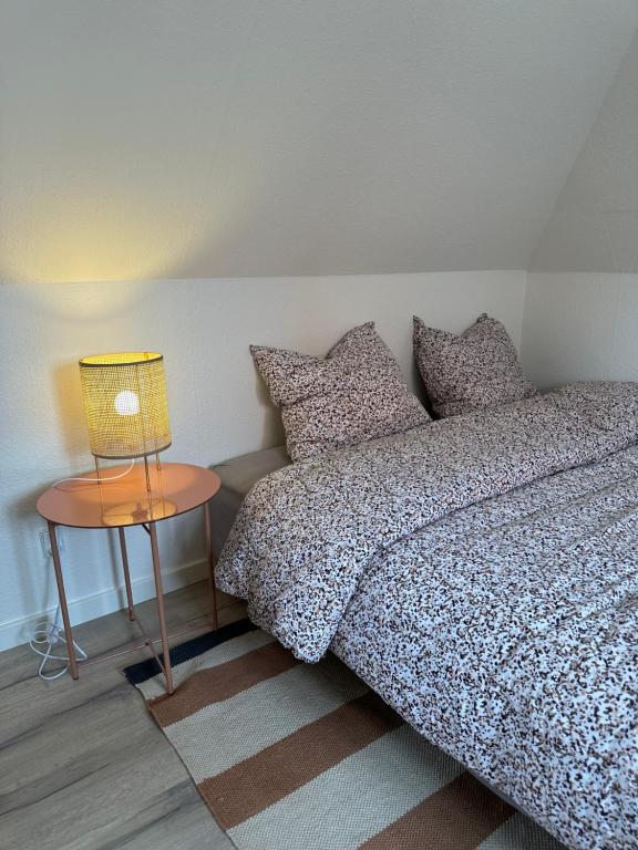 a bedroom with a bed and a side table at Loftlejlighed i centrum in Ringkøbing