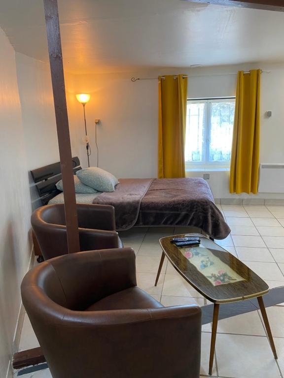a bedroom with a bed and a chair and a table at Locations de la centrale de Belleville in Neuvy-sur-Loire