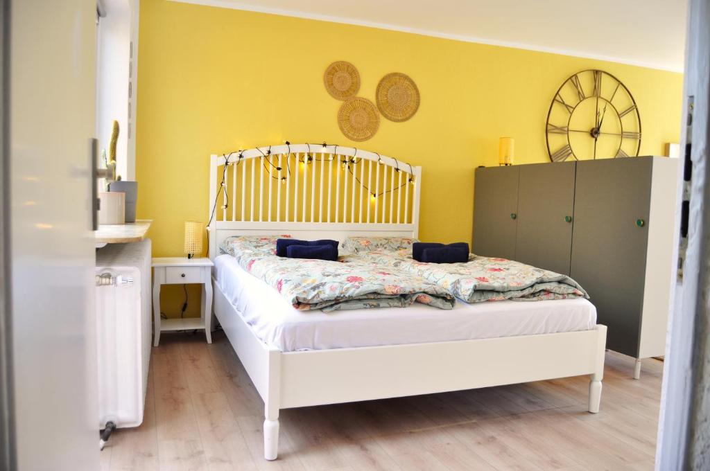 a bedroom with a white bed and a yellow wall at Akram Appartement II - Studio - Zentral und Ruhig in Hildesheim