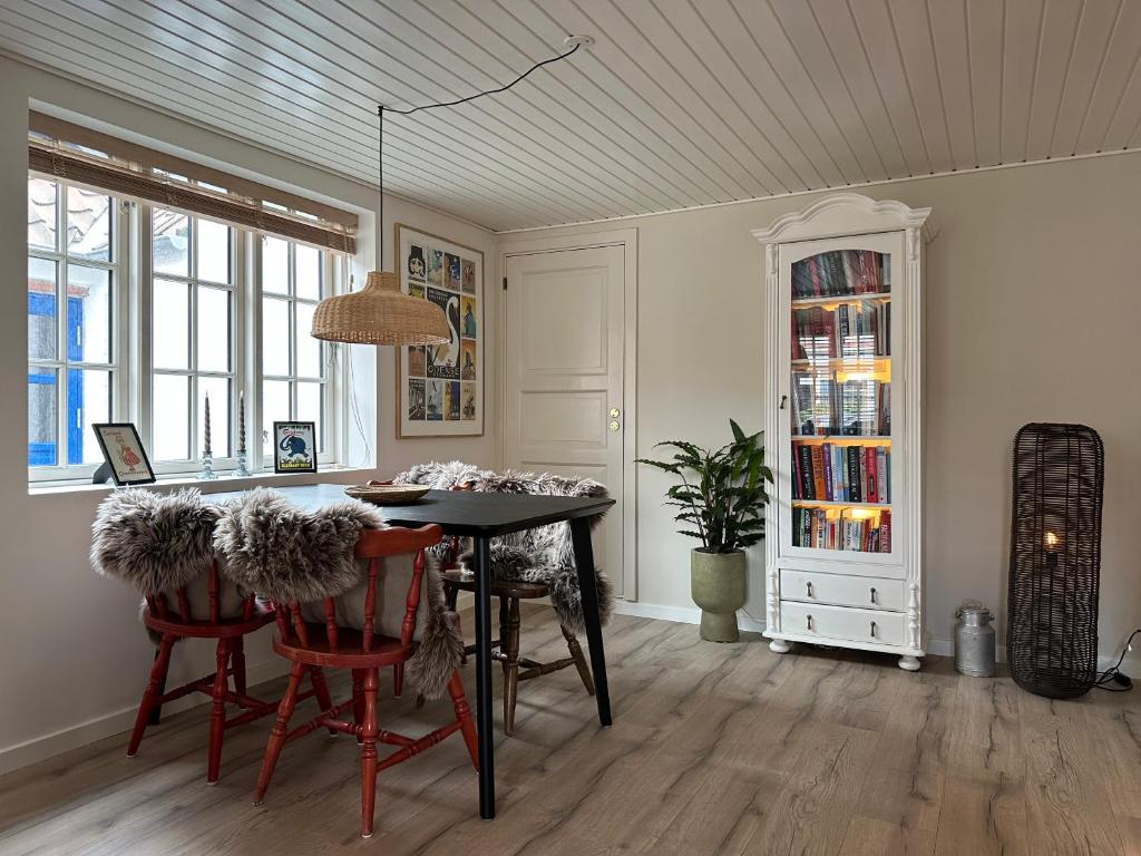 a dining room with a table and chairs at Charmerende stue lejlighed i centrum in Ringkøbing
