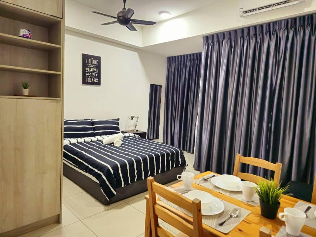 Schlafzimmer mit einem Bett und einem Esstisch in der Unterkunft 1 Dream Home @ Utropolis Studio 4星级简单舒适享受漂亮夜景和泳池 in Shah Alam