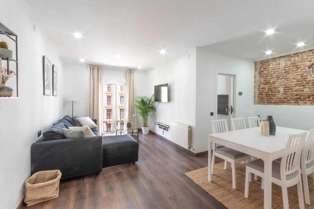 a living room with a black couch and a table at Design apartment plaça La font in Tarragona
